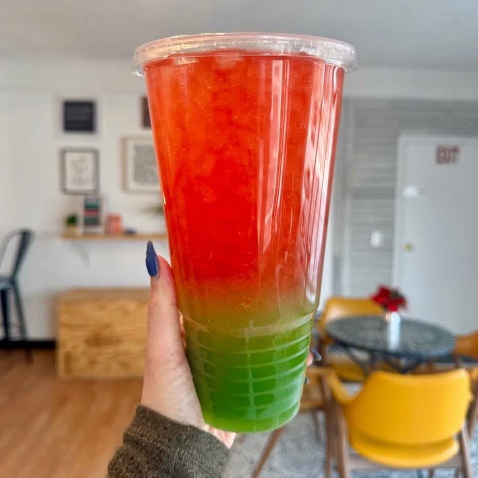 A watermelon loaded tea with red and green layers held up inside the club
